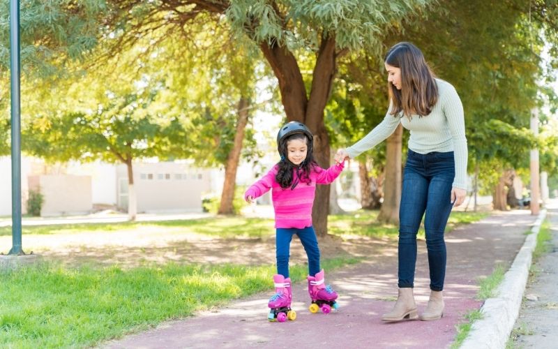 Kid roller skating with mom